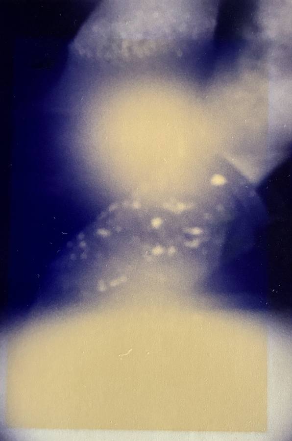 Pinhole photograph: a pale glow above, a pale band below, joined by blue and scattered light