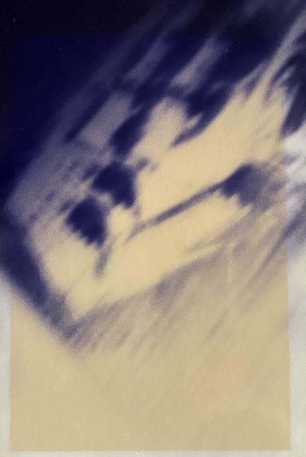 Pinhole photograph: streaked pale and blue forms tilting across the sheet