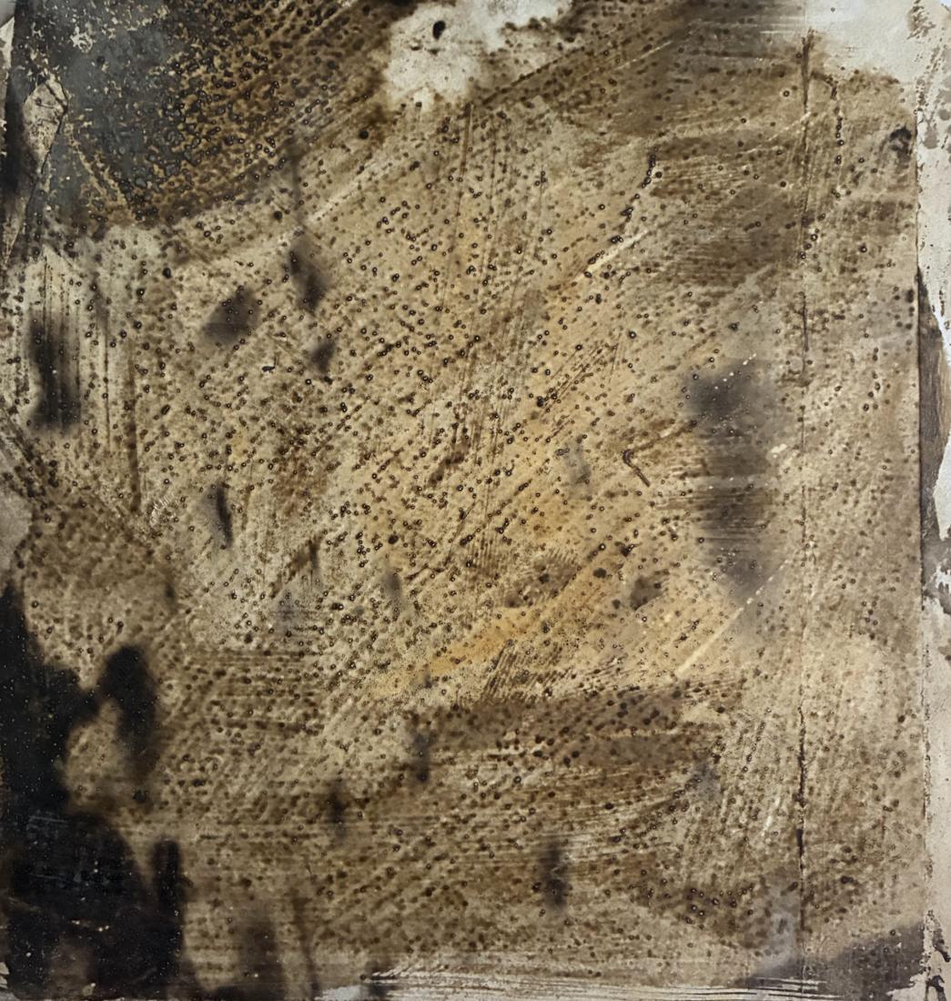 Test strip: pale sepia ground of diagonal brush marks with dark blots along the left edge